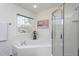 Bright bathroom featuring a corner tub, separate shower and a window with natural light at 213 Yellow Poplar Ave, Wake Forest, NC 27587