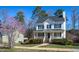 Beautiful two-story home with a front porch, surrounded by lush landscaping and flowering trees at 213 Yellow Poplar Ave, Wake Forest, NC 27587