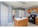 Spacious kitchen with a center island, oak cabinets, and black appliances, perfect for culinary enthusiasts at 213 Yellow Poplar Ave, Wake Forest, NC 27587