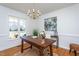 Bright office space with a wooden desk, chandelier, and large window overlooking the yard at 213 Yellow Poplar Ave, Wake Forest, NC 27587