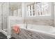 Bright bathroom featuring a soaking tub with marble tile and a glass shower at 2325 Old Oak Pl, Hillsborough, NC 27278