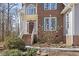 Inviting entrance featuring a covered porch, brick steps, and a solid wood front door with glass accents at 2325 Old Oak Pl, Hillsborough, NC 27278