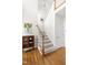 Hallway features hardwood floors, a staircase with white railings, and a display cabinet at 2325 Old Oak Pl, Hillsborough, NC 27278