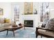 Bright living room with fireplace, large windows, and stylish decor, including a patterned rug at 2325 Old Oak Pl, Hillsborough, NC 27278