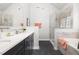 Elegant bathroom with double sinks, soaking tub, glass shower, and marble tile at 2325 Old Oak Pl, Hillsborough, NC 27278