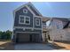 Two-story blue home with stone accents, an attached garage, and a second-story balcony at 247 Meadowbark Bnd # 29, Garner, NC 27529