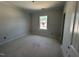 Empty bedroom with white walls and trim; a window offering neighborhood views at 251 Meadowbark Bnd # 30, Garner, NC 27529
