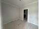 Empty bedroom with white walls, trim, one window, and an open doorway at 251 Meadowbark Bnd # 30, Garner, NC 27529