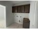 Laundry room view with upper cabinets, hookups, and a small lower cabinet at 251 Meadowbark Bnd # 30, Garner, NC 27529