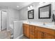 Well-lit bathroom with wooden cabinets, double sinks, and two large mirrors for convenience at 2822 Casona Way, Raleigh, NC 27616