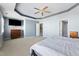 Bright bedroom featuring a tray ceiling, ceiling fan, and multiple entryways at 2822 Casona Way, Raleigh, NC 27616