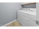 A well-lit laundry area with a white washer and dryer combination and tile flooring at 2822 Casona Way, Raleigh, NC 27616