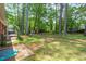 Spacious backyard featuring mature trees, a well-manicured lawn, and an outdoor play area at 2968 Tram Rd, Fuquay Varina, NC 27526