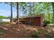 Landscaped backyard featuring a brick home, mature trees, and a well-maintained lawn at 2968 Tram Rd, Fuquay Varina, NC 27526