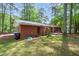 Exterior view of a charming brick home with a covered patio and a lush green lawn at 2968 Tram Rd, Fuquay Varina, NC 27526