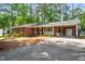 A brick ranch style home, showing the front yard and carport, and lush landscaping at 2968 Tram Rd, Fuquay Varina, NC 27526