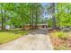 Charming brick ranch-style home with a long driveway and mature trees offering great curb appeal at 2968 Tram Rd, Fuquay Varina, NC 27526