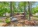 Brick ranch home nestled among mature trees with an outbuilding, surrounded by beautiful landscaping at 2968 Tram Rd, Fuquay Varina, NC 27526