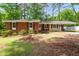 Charming brick home featuring a covered porch, well-maintained landscaping, and a carport at 2968 Tram Rd, Fuquay Varina, NC 27526