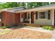 A welcoming covered front porch with chairs and hanging baskets. Brick and siding home at 2968 Tram Rd, Fuquay Varina, NC 27526
