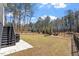 Beautiful backyard with lush lawn, mature trees, and black iron fence creates a serene outdoor setting at 298 Bonterra Way, Chapel Hill, NC 27516