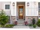 Inviting front entrance features stone accents, a wooden door, and decorative potted plants at 298 Bonterra Way, Chapel Hill, NC 27516