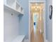 Hallway featuring a custom white storage bench, hardwood floors, and blue painted walls at 298 Bonterra Way, Chapel Hill, NC 27516