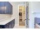 Convenient laundry room featuring modern blue cabinetry, white countertops, and access to a walk-in closet at 298 Bonterra Way, Chapel Hill, NC 27516