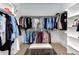 Spacious walk-in closet featuring organized clothing racks, shelves, and bench at 298 Bonterra Way, Chapel Hill, NC 27516