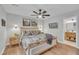 Bedroom featuring ceiling fan, a large bed with patterned quilt and ensuite bathroom entrance at 305 Dickens Rd, Fuquay Varina, NC 27526