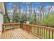 Wooden deck with black metal railings, offering a relaxing outdoor space with views of the surrounding trees and backyard at 305 Dickens Rd, Fuquay Varina, NC 27526