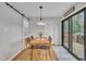 Bright dining area features hardwood floors, a modern table with seating for four, and sliding door access to the back deck at 305 Dickens Rd, Fuquay Varina, NC 27526