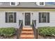 Close up of home entrance showing brick steps, black railings, and decorative lighting at 305 Dickens Rd, Fuquay Varina, NC 27526