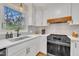 Bright kitchen with stainless steel appliances, white cabinets, gray backsplash, and a view to the outdoors at 305 Dickens Rd, Fuquay Varina, NC 27526