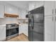 Kitchen features white cabinetry, stainless appliances, and an island with a breakfast bar at 305 Dickens Rd, Fuquay Varina, NC 27526