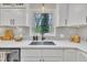 Modern kitchen sink with quartz countertops, white cabinets, and stainless steel appliances at 305 Dickens Rd, Fuquay Varina, NC 27526
