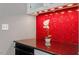 Stylish bar area with red backsplash, granite counter, and white cabinets with glass doors at 321 E Lane St, Raleigh, NC 27601