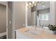 Bathroom featuring a sink with marble countertop, large mirror with vanity lights, and neutral wall color at 321 E Lane St, Raleigh, NC 27601