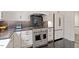 Modern kitchen featuring stainless steel appliances, white cabinetry, and black countertops at 321 E Lane St, Raleigh, NC 27601