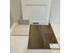 Sample board of white kitchen cabinet door, countertop, backsplash, and luxury vinyl plank flooring at 340 Chesapeak Commons St # 139, Garner, NC 27529