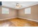 Bedroom with hardwood floors, two windows, and ceiling fan provides abundant natural light at 3617 Cranston Rd, Garner, NC 27529