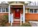 Welcoming front porch with a red door, classic white railing, and brick accents, complemented by green shutters at 3617 Cranston Rd, Garner, NC 27529