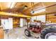 Spacious garage contains tractor, white cabinets, workbench, and shelving at 3617 Cranston Rd, Garner, NC 27529