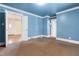 A blue living room boasts hardwood flooring, white trim and multiple entryways at 3617 Cranston Rd, Garner, NC 27529