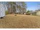 Spacious backyard featuring a storage shed, mature trees, and a playground, perfect for outdoor enjoyment and recreation at 402 Abbott Dr, Sanford, NC 27330