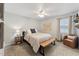 Cozy bedroom featuring a ceiling fan, a wooden bed frame, and a comfortable chair near the window at 402 Abbott Dr, Sanford, NC 27330