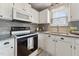 Updated kitchen features granite counters, stainless sink, and white appliances at 402 Abbott Dr, Sanford, NC 27330