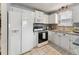 Well-lit kitchen with white appliances, granite countertops, and tile flooring at 402 Abbott Dr, Sanford, NC 27330