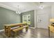 Bright dining area with wood-look flooring, a farmhouse table and a view of the front entrance at 42 Chris Todd Way, Angier, NC 27501