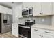 Bright kitchen with stainless steel oven, microwave, and refrigerator, and white cabinets at 42 Chris Todd Way, Angier, NC 27501